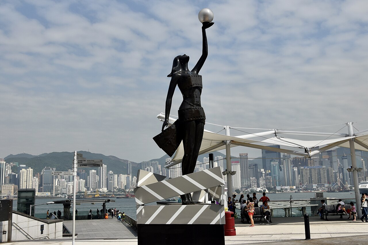 星光大道上的香港電影金像獎小金人雕像，背景是維港